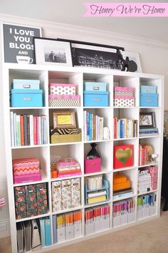 a white bookcase filled with lots of books and other items on top of it