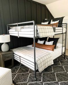 bunk beds are stacked on top of each other in a room with black and white walls