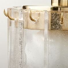 a close up of a light fixture with water droplets on the glass and brass handles