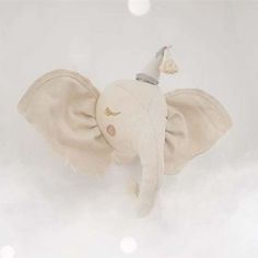 an elephant stuffed animal with a party hat on it's head in the clouds