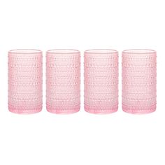 four pink glass tumblers sitting next to each other