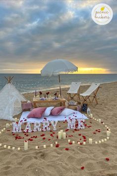 an outdoor wedding setup on the beach with candles in the shape of letters and flowers