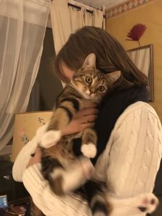 a woman holding a cat in her arms