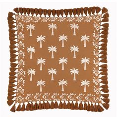 a brown and white pillow with palm trees on it