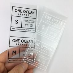 one ocean apparel stickers are being held up by someone's hand