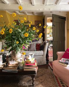 a living room filled with furniture and yellow flowers