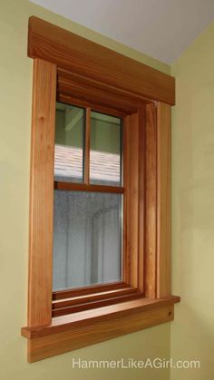 a wooden window frame in a yellow room with white walls and wood trimmings