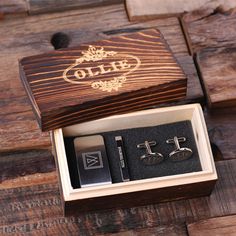 an open wooden box with two pairs of cufflinks and a pair of earrings in it