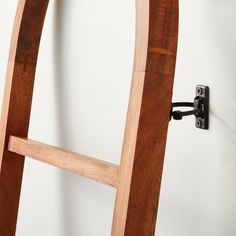 a close up of a wooden chair with a metal hook on the back and side