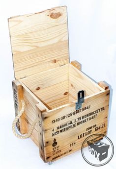 an empty wooden box sitting on top of a white surface with a rope attached to it