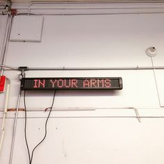 a sign that is hanging on the side of a wall with wires attached to it