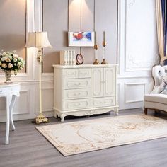 a living room with white furniture and flowers in vases on the dresser next to it