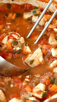 a pot filled with chicken and vegetables being stirred with a ladle to stir the soup