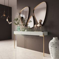 two mirrors are hanging on the wall above a console table with vases and lamps