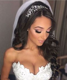 a woman in a wedding dress with a veil on her head wearing a tiara