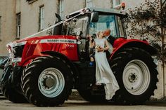 a bride and groom kissing in front of a red tractor with the words married written on it