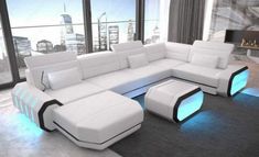 a modern living room with white leather furniture and large windows overlooking the cityscape