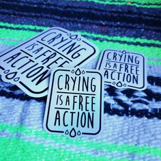 three black and white signs sitting on top of a green tablecloth covered floor next to each other