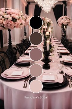 the table is set with black and white plates, silverware, pink flowers and candles