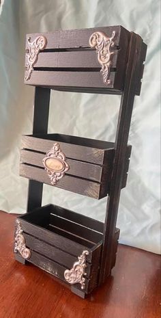 three wooden crates stacked on top of each other with decorative carvings and handles, sitting on a wood table