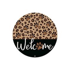 a round sign that says welcome with leopard print and paw prints on the front side