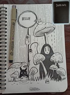 a notebook with an image of mushrooms on it and a pen next to the book