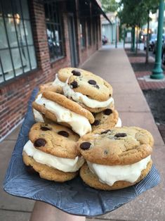 there are cookies and ice cream sandwiches on the blue plate in front of the building