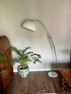 a living room with a wooden floor and a large lamp on the side of the wall