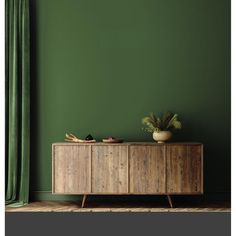 a green room with a wooden cabinet and potted plant