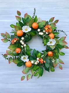 a wreath with oranges and white flowers