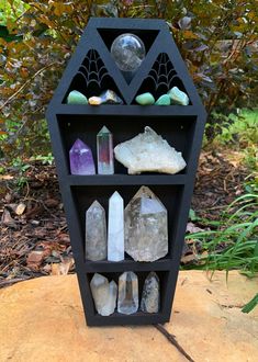 a shelf filled with different types of rocks and crystals on top of a tree stump