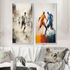 two paintings depicting soccer players are hanging on the wall above a couch in a living room