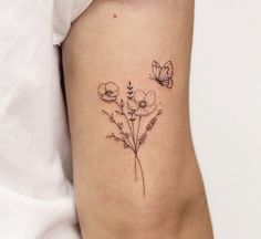 a small flower tattoo on the right side of the leg, with two butterflies flying over it