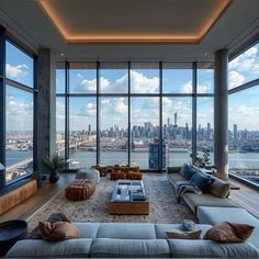 a living room filled with lots of furniture and large windows over looking the cityscape