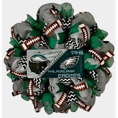 the philadelphia eagles mesh wreath is decorated with footballs and green, white, and black