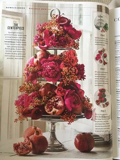 an open magazine with red flowers and fruit on the cover, sitting on a table