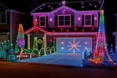 a house covered in christmas lights and trees