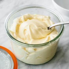 a glass jar filled with cream sitting on top of a table