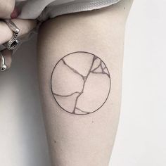 a woman's arm with a circle tattoo on it, which has been drawn in black ink