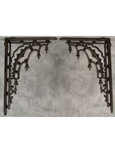 an ornate iron wall shelf against a gray background