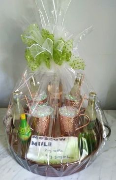 a basket filled with lots of different types of drinks and snacks in plastic wrap on top of a table