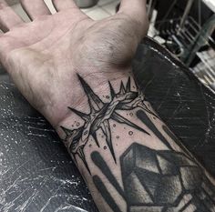 a man's hand with a cross tattoo on it