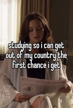 a woman sitting on a bed reading a paper with the capt saying studying so i can get out of my country the first chance i get