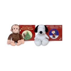 two stuffed animals sitting next to each other in front of a christmas card and book