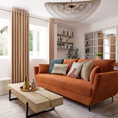 a living room with an orange couch and coffee table in front of the window,