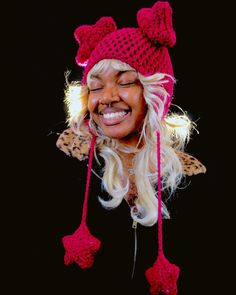 a woman with blonde hair wearing a red knitted hat