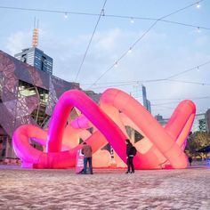 two people are standing in front of an art installation that looks like the letters love