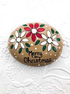 a rock painted with flowers and merry christmas written on it