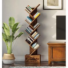 a tall wooden book shelf sitting next to a potted plant