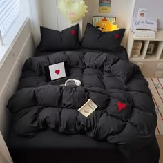 a bed with black comforter and pillows on it